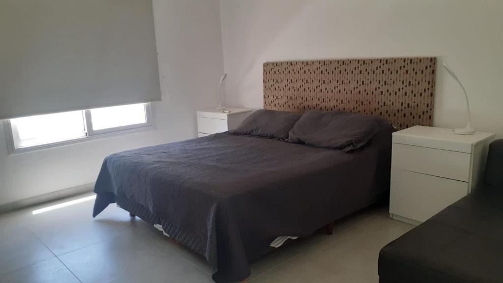 a bedroom with a large bed and two windows at Casa Olivia in Villa María