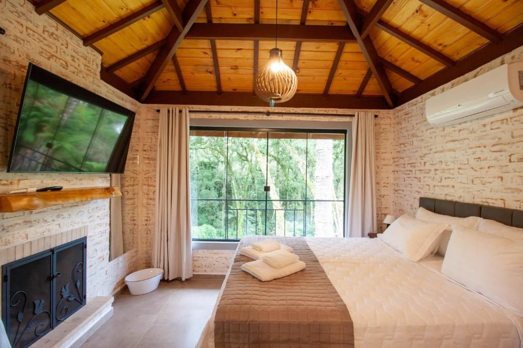 a bedroom with a large bed and a fireplace at Vivendas de Monte Verde in Monte Verde