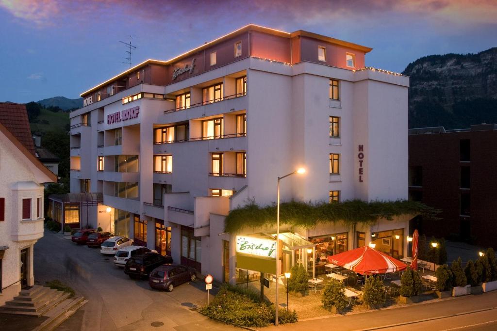 a large white building with cars parked in front of it at Hotel Bischof in Dornbirn