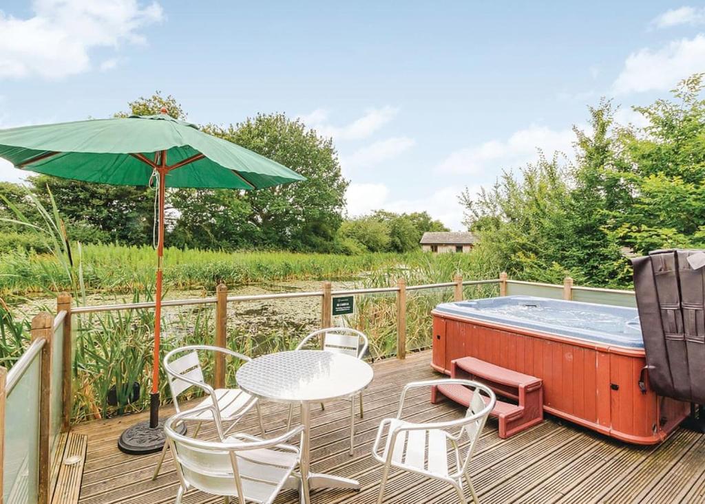 a deck with a table and chairs and a hot tub at Oakwood Lodges in Skipwith