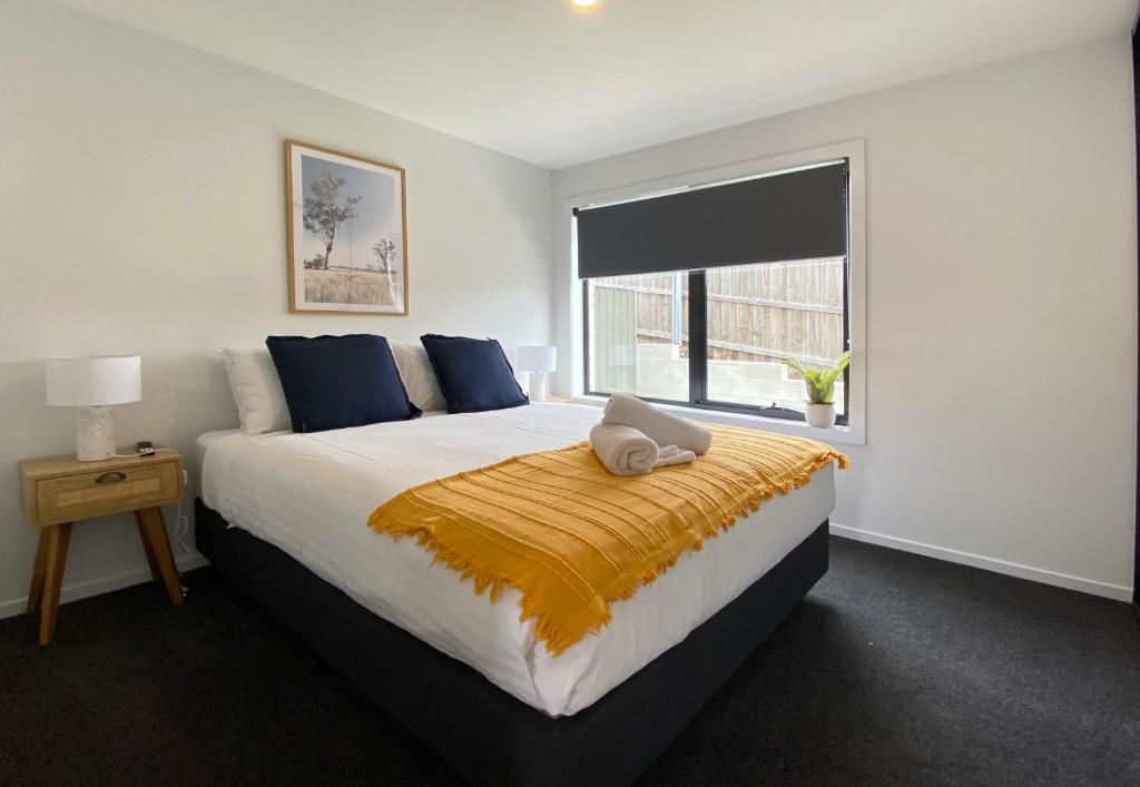 Albatross Rise - Modern Family Home في هوبارت: غرفة نوم بسرير كبير ونافذة