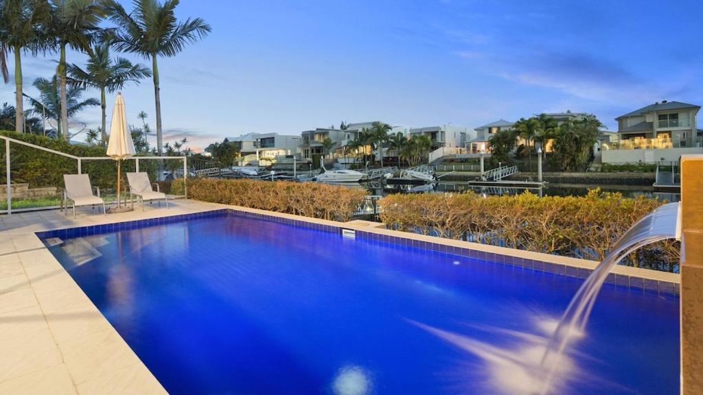 a blue swimming pool with a view of a city at Luxury waterfront house close to Theme Parks and shops in Gold Coast