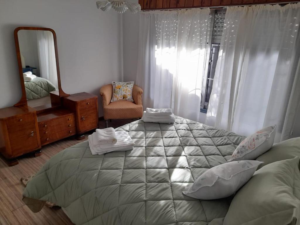 1 dormitorio con 1 cama grande y espejo en Hortencia en El Bolsón