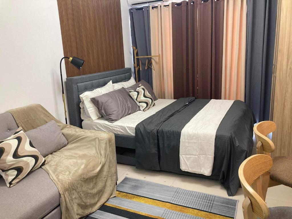 a bedroom with two beds and a couch at Alleia's Place at Tagaytay in Tagaytay