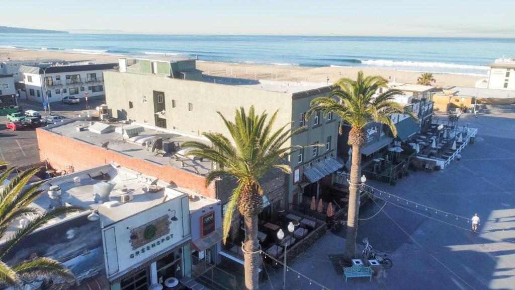 an aerial view of a resort with palm trees and the beach at ITH Los Angeles Beach Hostel in Hermosa Beach