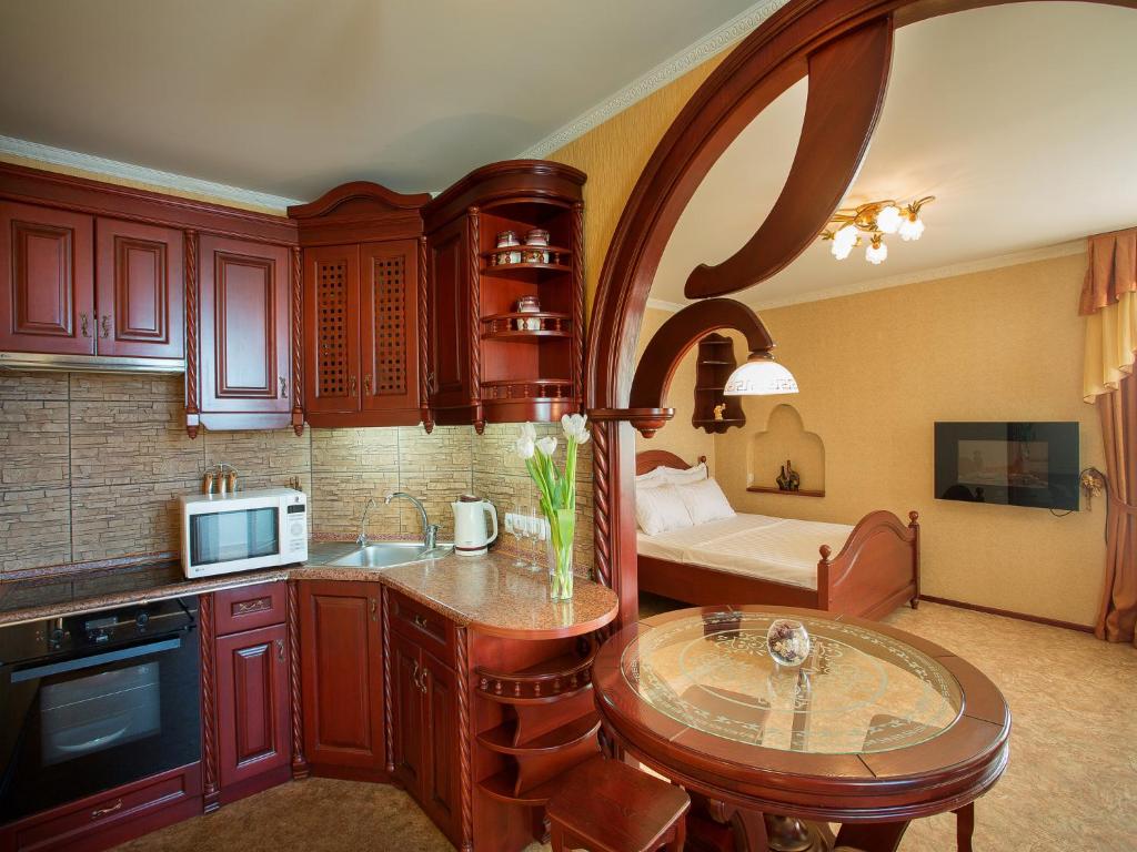 a kitchen with a table and a bed in a room at Studio De Luxe with Jacuzzi in Sumy