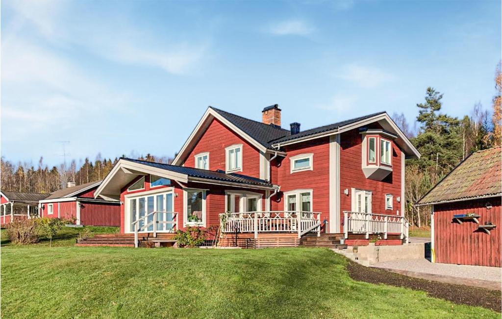 a large red house with a large yard at Awesome Home In Idkerberget With Lake View in Grangärde
