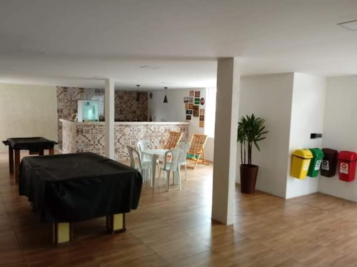 a living room with a table and a kitchen at Paradise Suítes in Arraial do Cabo