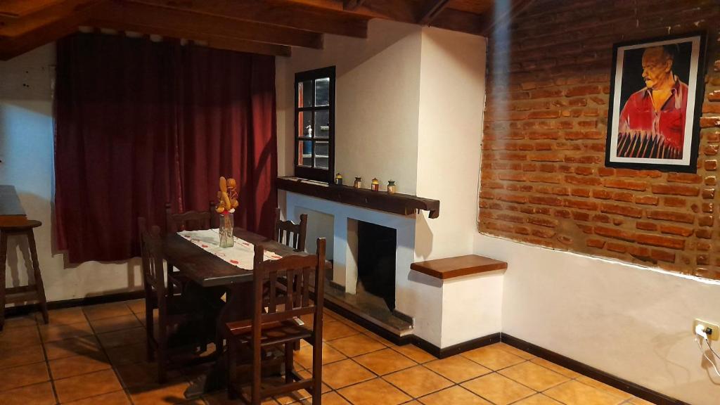a dining room with a table and a fireplace at Departamento Los Nogales I in San Fernando del Valle de Catamarca