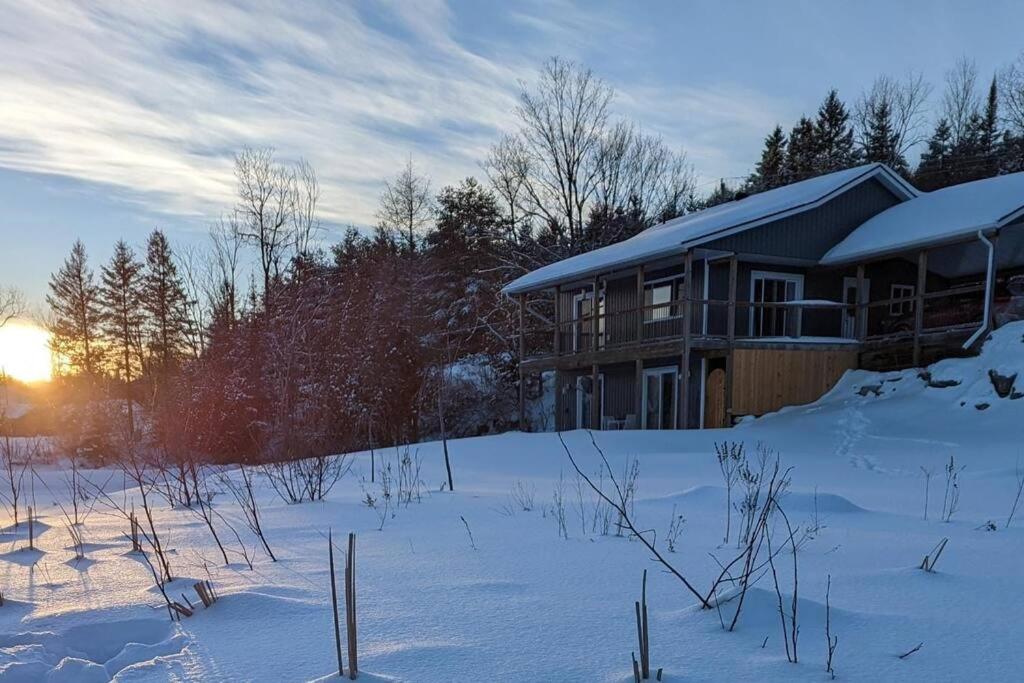 uma casa na neve com o pôr do sol atrás dela em Marshmallow home em Gilmour