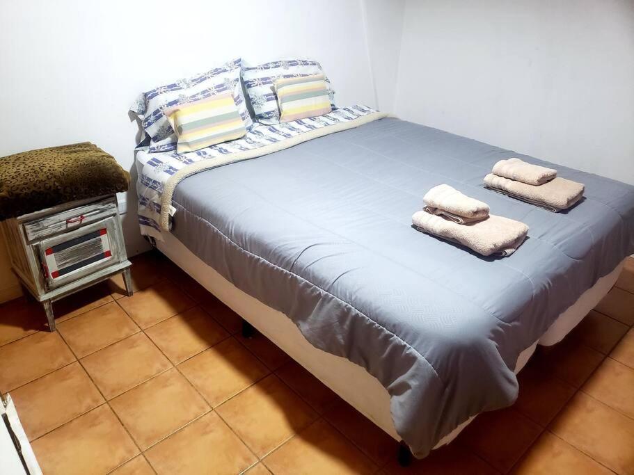 1 dormitorio con 1 cama grande y toallas. en Gran Apartamento Cómodo y Lindo en Ushuaia