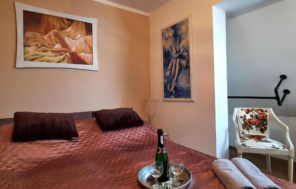 a bedroom with a bed with a bottle of wine on it at Apartament przy Rynku in Białystok