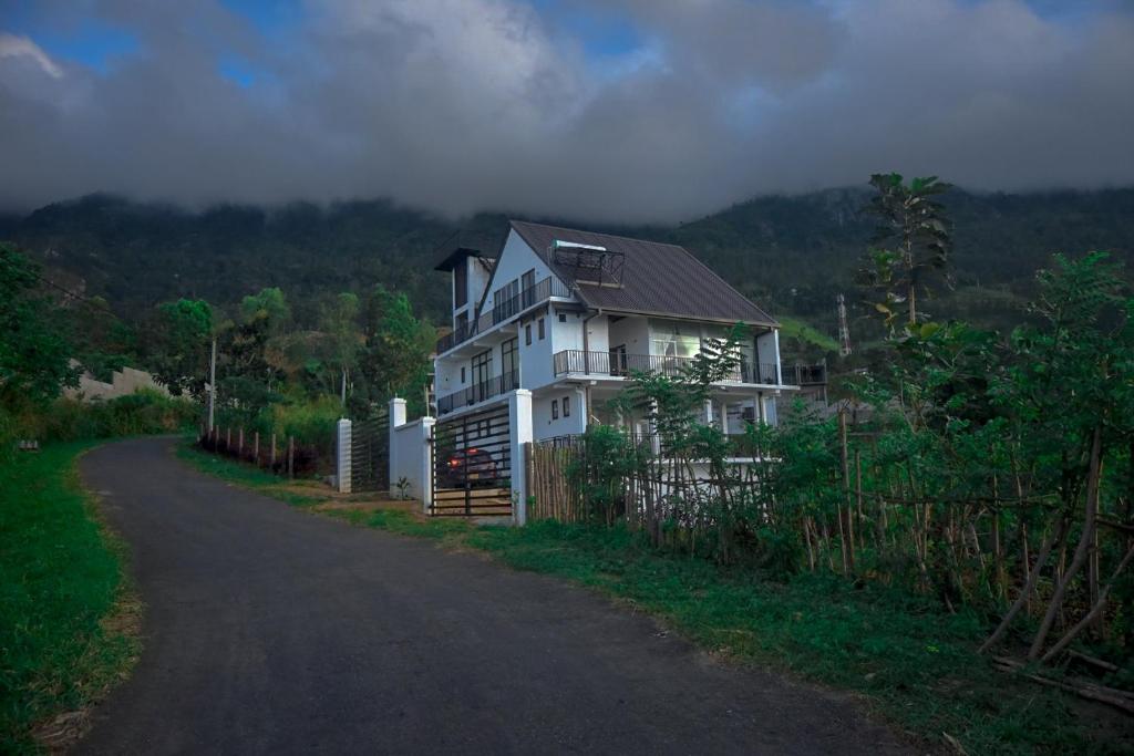 een wit huis aan de kant van een weg bij Tranquil Edge Villa in Haputale