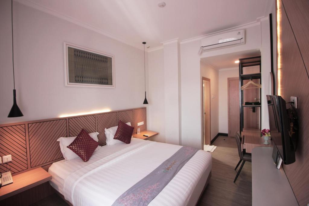 Postel nebo postele na pokoji v ubytování Muara Hotel Bukittinggi