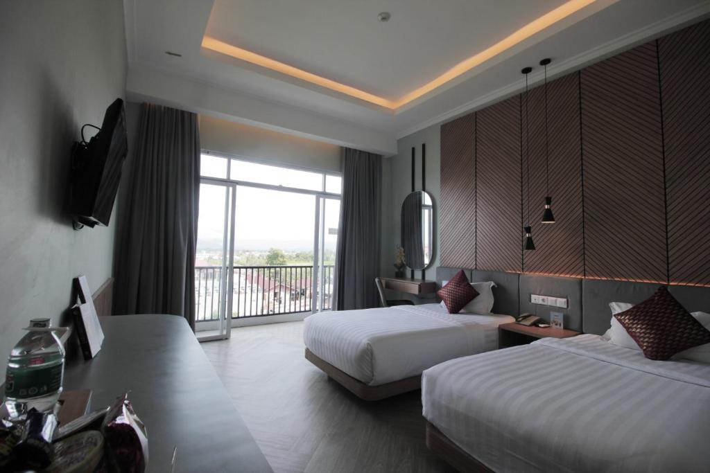 Postel nebo postele na pokoji v ubytování Muara Hotel Bukittinggi
