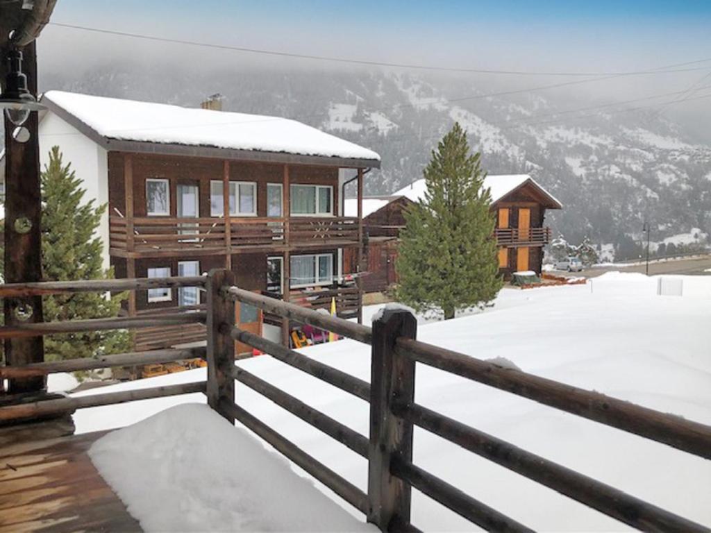 a log cabin in the snow with a fence at Mon Raccard Cosy - 4 vallées in Bruson