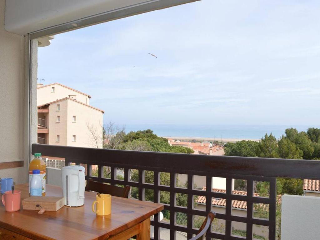 uma mesa numa varanda com vista para o oceano em Appartement Fleury-Saint-Pierre-la-Mer, 1 pièce, 5 personnes - FR-1-229D-222 em Saint Pierre La Mer