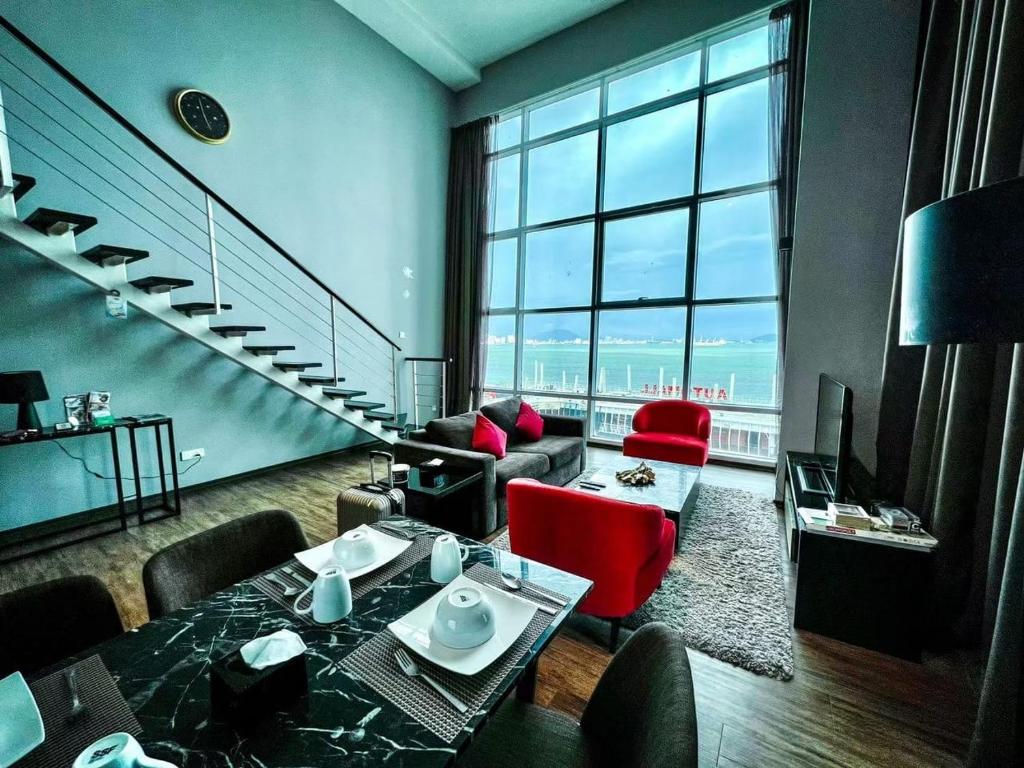 a living room with a staircase and red chairs at Urbano Luxury Maritime Suite in George Town