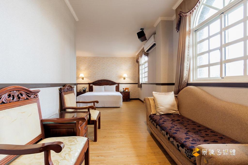 um quarto de hotel com uma cama e um sofá em Fu Bao Motel em Hualien City