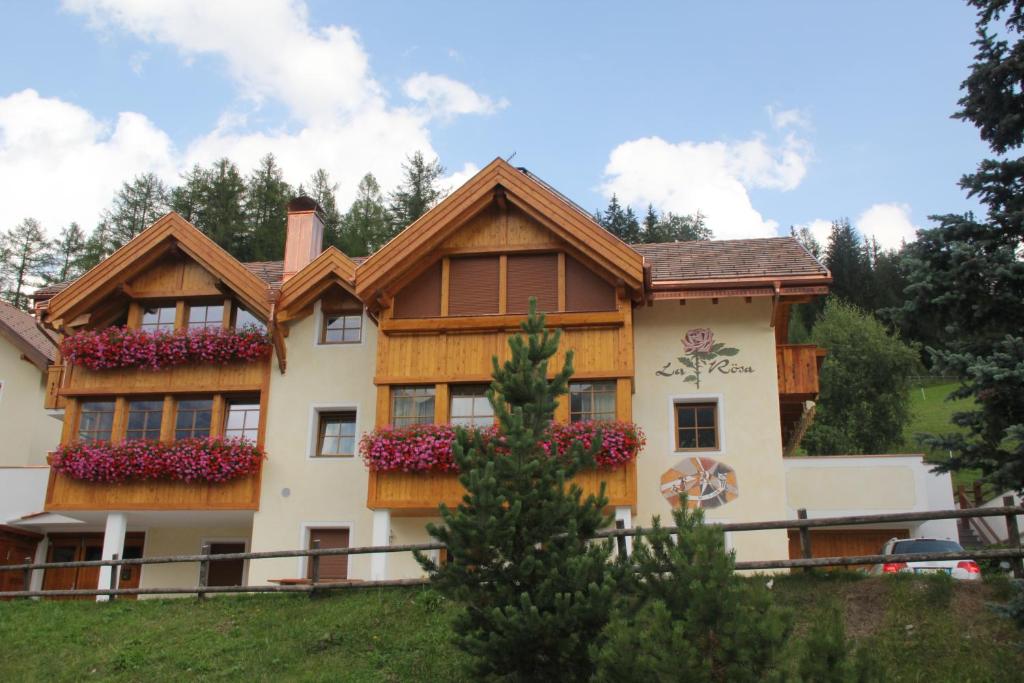 a house with flower boxes on the side of it at Ciasa La Rösa in Badia