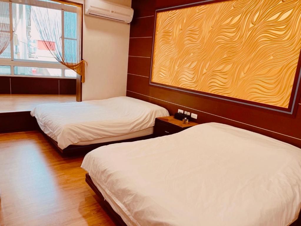 a room with two beds and a window at Jinye B&B 金夜民宿 in Xiaoliuqiu
