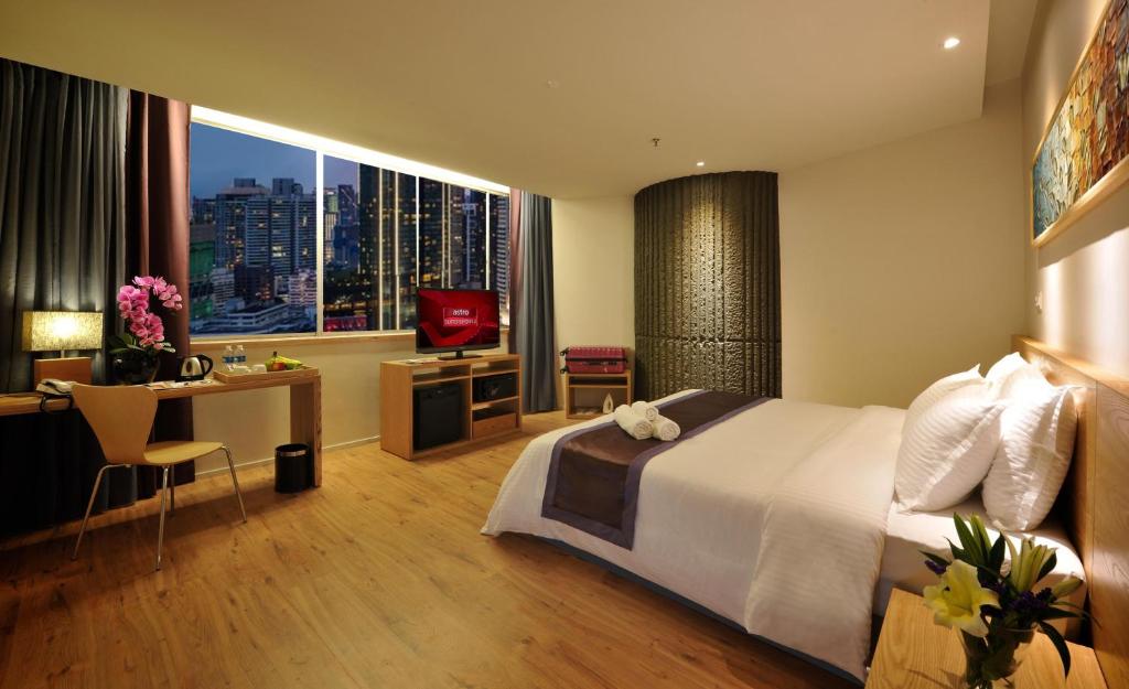 a bedroom with a bed and a desk and a television at de King Boutique Hotel KLCC in Kuala Lumpur