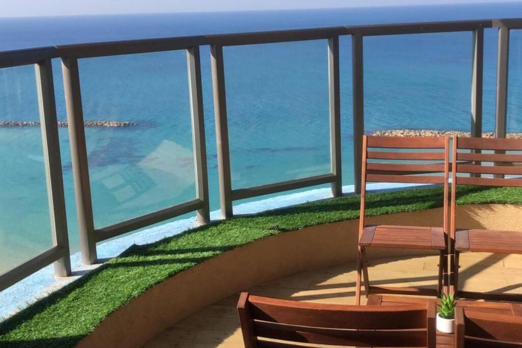 uma varanda com um banco e vista para o oceano em apartment with sea view- itallian jaccuzi em Netanya