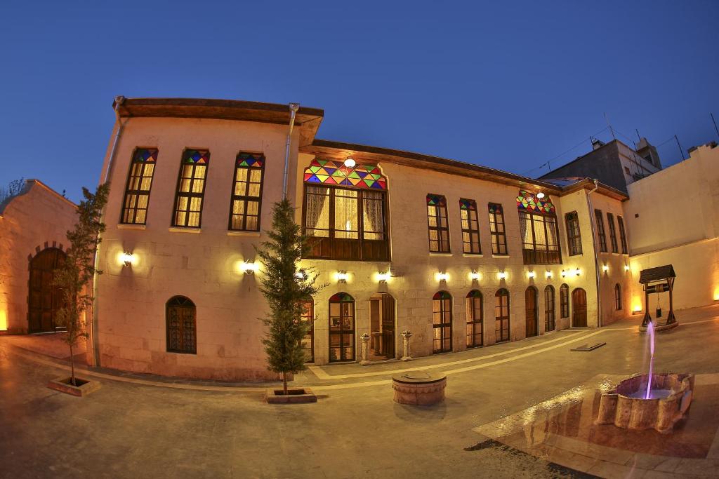 Um edifício antigo com uma árvore de Natal à frente. em Ali Bey Konagi em Gaziantep