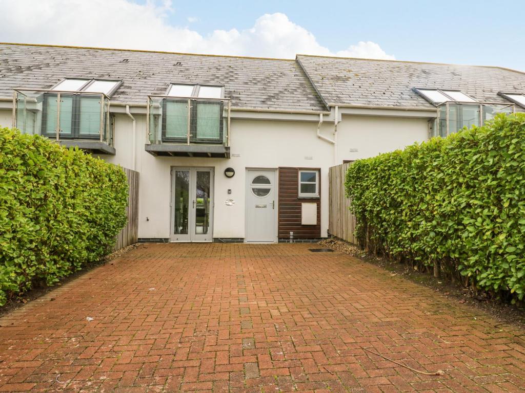 a white house with a brick driveway at 19 Bay Retreat Villas in St Merryn