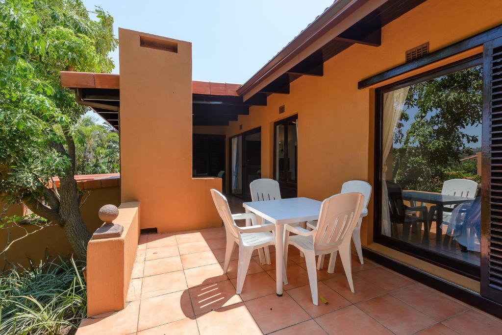 una casa con patio con mesa y sillas en San Lameer Villa 2843 - 2 Bedroom Classic - 4 pax - San Lameer Rental Agency, en Southbroom