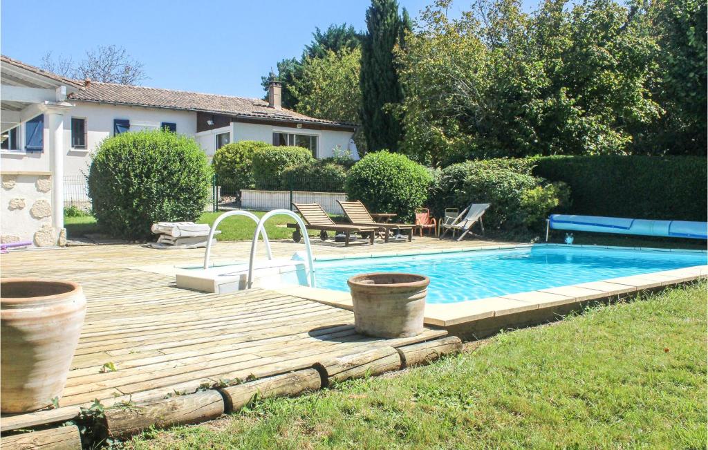 una piscina con terrazza in legno accanto a una casa di Beautiful Home In Atur With Outdoor Swimming Pool, Wifi And 3 Bedrooms ad Atur