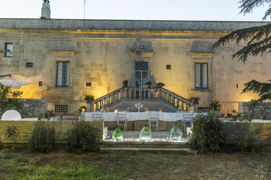 un edificio con una mesa y sillas delante de él en Trapetum-Salento domus, en Cursi