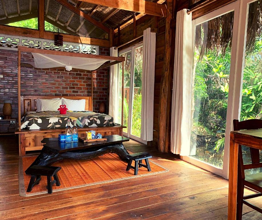 a bedroom with a bed and a table in it at Bamboo Cottages in Phu Quoc