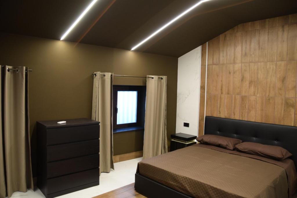 um quarto com uma cama, uma cómoda e uma janela em Rebecca House suites em Catânia