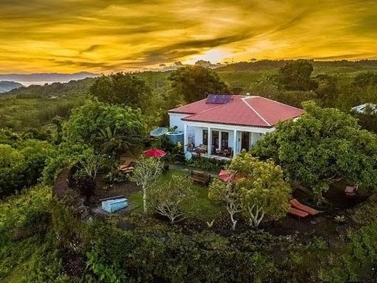 Balibo Fort Hotel في Balibo: بيت ابيض صغير بسقف احمر