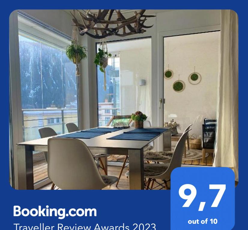 Apartment Bellania في دافوس: غرفة طعام مع طاولة مع كراسي ونافذة