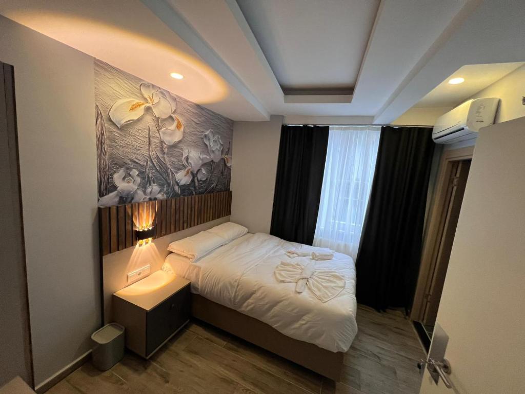 Mudem Boutique Hotel في إسطنبول: غرفة نوم بسرير مع لوحة على الحائط