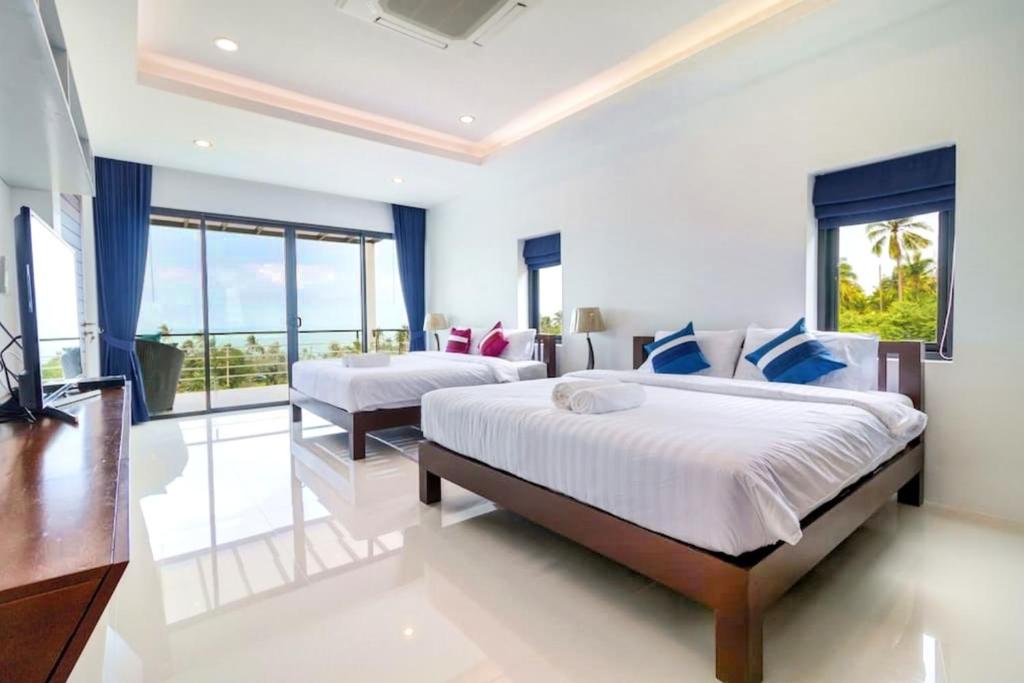 a bedroom with two beds and a large window at Sea VIEW POOL Villa - 8 peoples- Private Pool - Beautiful garden in Ban Bang Po