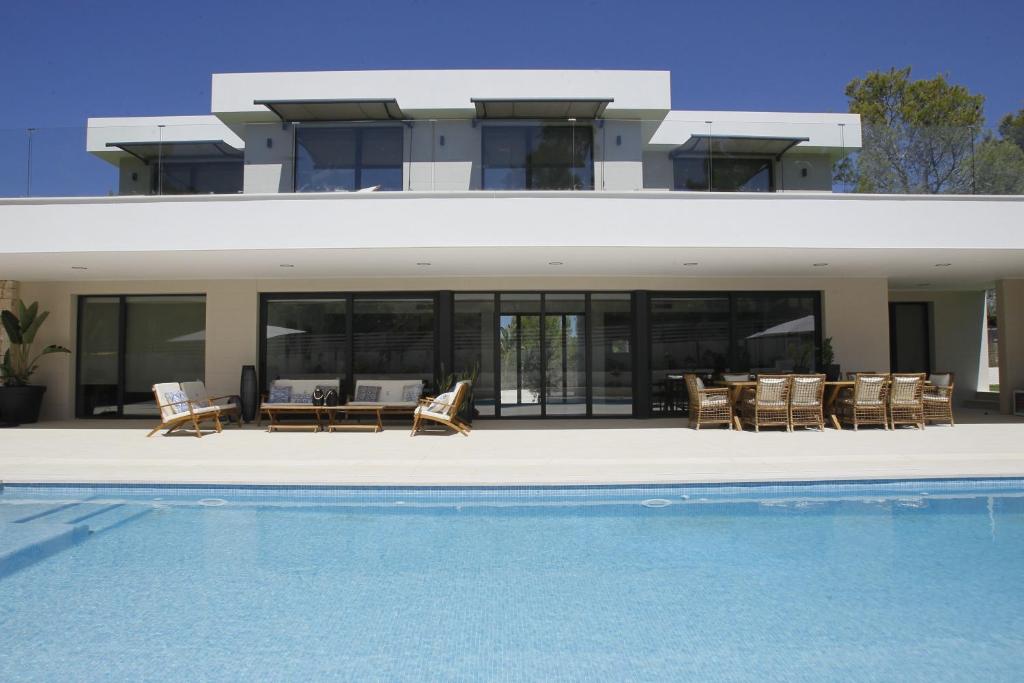 a house with a swimming pool in front of it at VILLA SP SUITES SANTA PONSA in Santa Ponsa