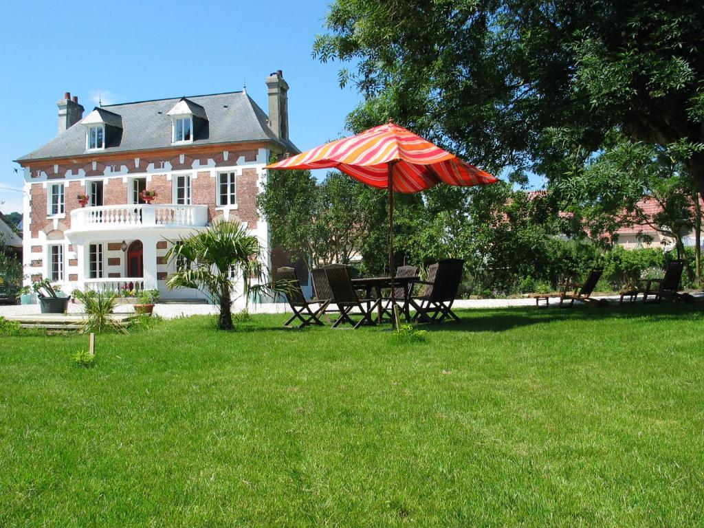 - une table de pique-nique avec un parasol en face d'une maison dans l'établissement Chambres d'Hôtes Villa Mon Repos, à Saint-Aubin-sur-Scie