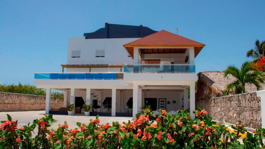 a house on the beach with flowers in the foreground at Hotel Capriccio Mare y Restaurante in Punta Cana