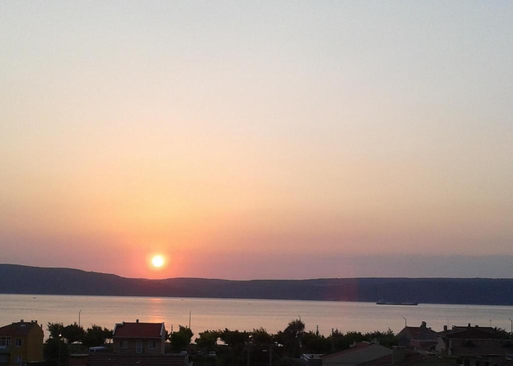 una puesta de sol sobre un cuerpo de agua en Troya Apart Çanakkale, en Canakkale