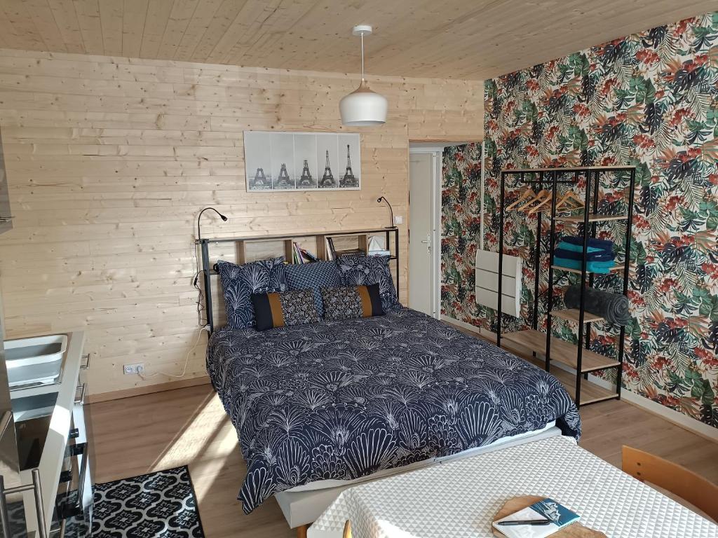une chambre avec un lit dans une pièce dans l'établissement Charmant studio proche canal., à Châteauneuf-du-Faou