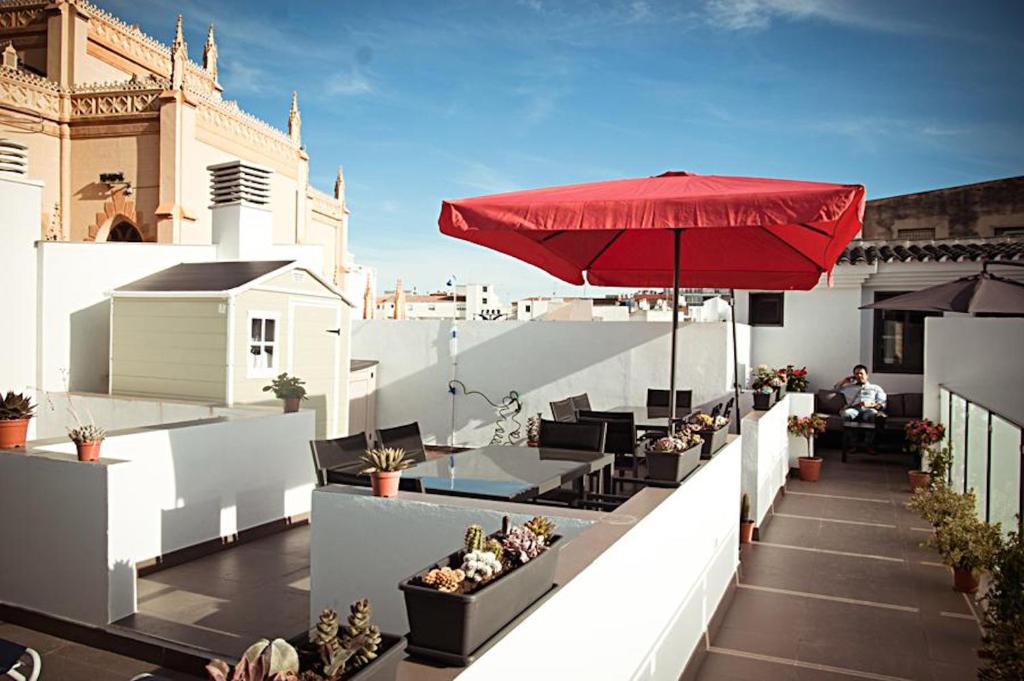 a restaurant with tables, chairs and umbrellas at Apartamentos San Pablo in Málaga