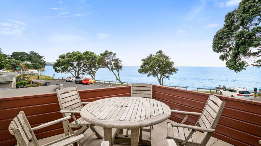 una mesa y sillas en un balcón con vistas al océano en Remarkable Red Beach - Red Beach Holiday Home en Red Beach