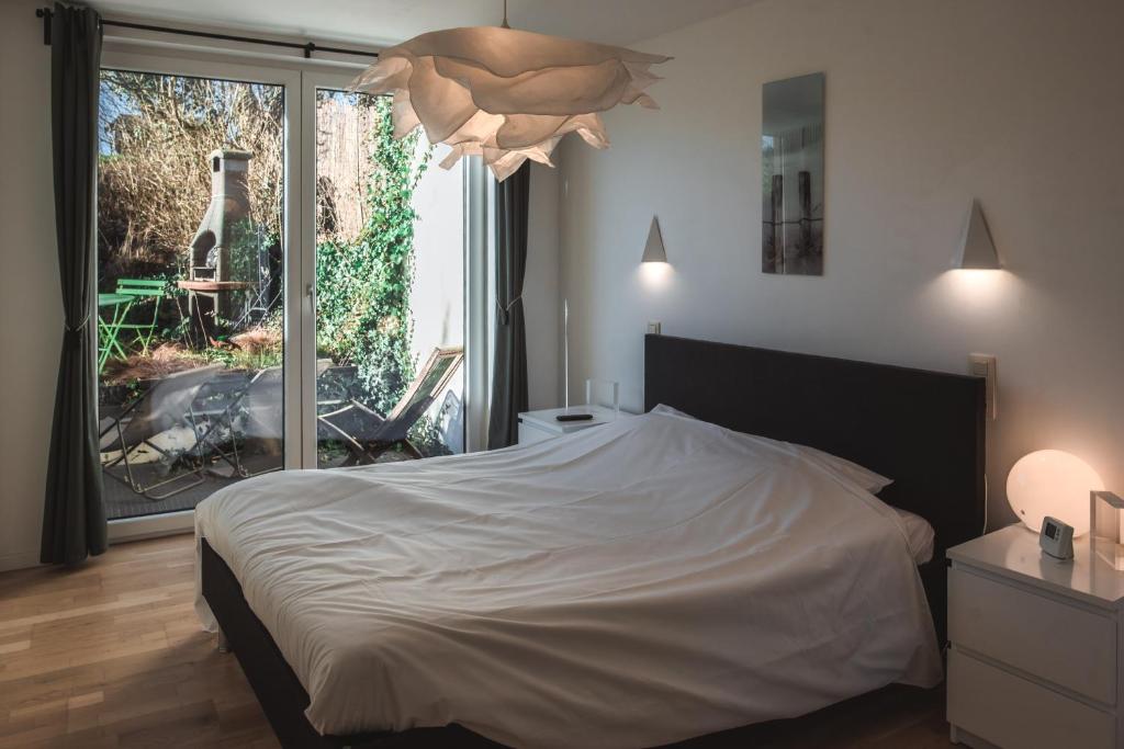 sypialnia z białym łóżkiem i dużym oknem w obiekcie Gîte de L´ô d´Or w mieście Villers-devant-Orval