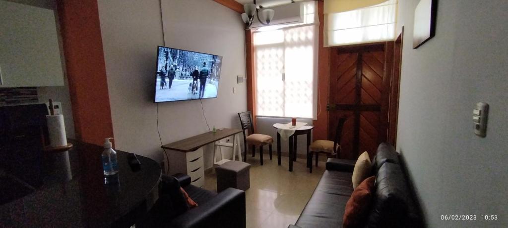 uma sala de estar com um sofá e uma televisão na parede em Departamento entero con vista al río em Iquitos