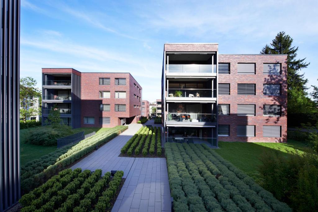 ツークにあるCity Apartmentsの庭園を正面に望むアパートメントビル