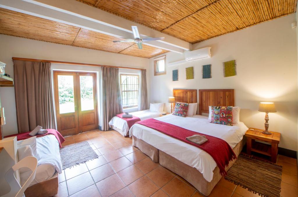 una camera con due letti e un soffitto di At the Woods Guest House a Stormsrivier