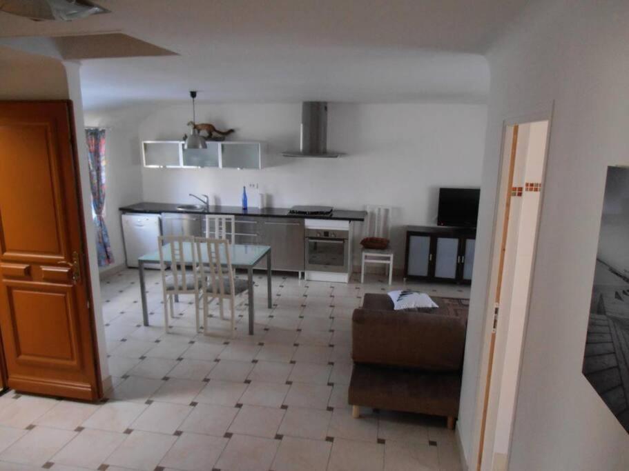cocina y sala de estar con mesa y sillas en Gîtes des Isles - Le Jersey, en Barneville-Carteret